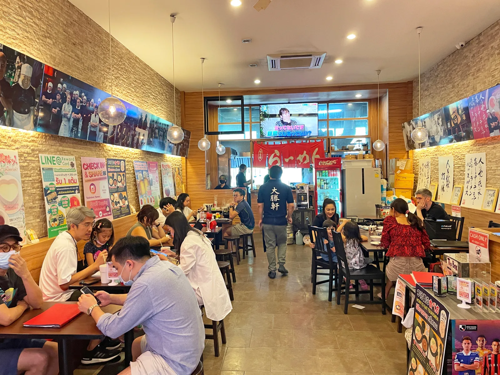 ภายในร้านไทโชเคน กรุงเทพฯ พร้อมผนังตกแต่งด้วยไม้และโต๊ะอาหาร
